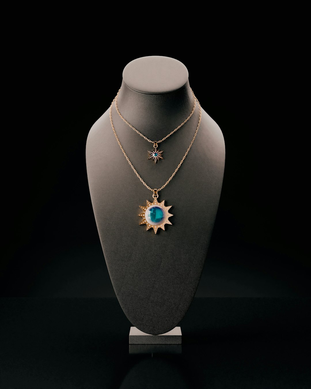 two-sun-shaped-necklaces-displayed-on-a-bust-tr3awabuqag